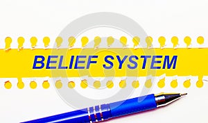 Blue pen and white torn paper stripes on a bright yellow background with the text BELIEF SYSTEM