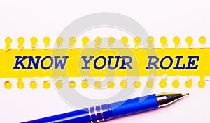 Blue pen and white torn paper stripes on a bright yellow background with the text KNOW YOUR ROLE