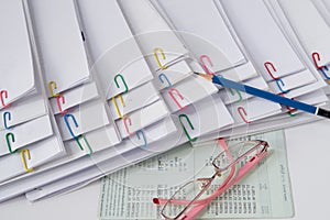 Blue pencil put on stack of overload paper and reports