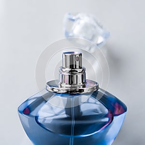 Blue perfume bottle on glossy background, sweet floral scent, glamour fragrance and eau de parfum as holiday gift and luxury