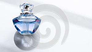 Blue perfume bottle on glossy background, sweet floral scent, glamour fragrance and eau de parfum as holiday gift and luxury