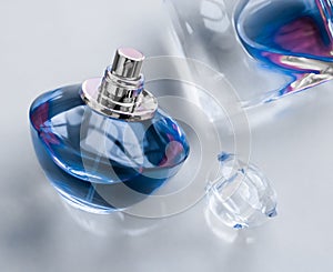 Blue perfume bottle on glossy background, sweet floral scent, glamour fragrance and eau de parfum as holiday gift and luxury