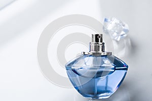 Blue perfume bottle on glossy background, sweet floral scent, glamour fragrance and eau de parfum as holiday gift and luxury