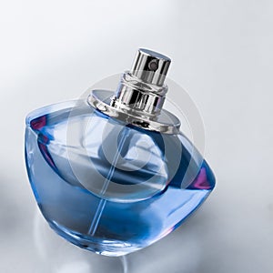 Blue perfume bottle on glossy background, sweet floral scent, glamour fragrance and eau de parfum as holiday gift and luxury