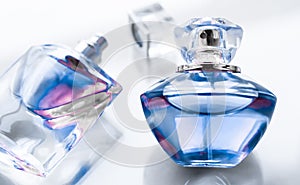 Blue perfume bottle on glossy background, sweet floral scent, glamour fragrance and eau de parfum as holiday gift and luxury