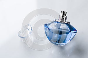 Blue perfume bottle on glossy background, sweet floral scent, glamour fragrance and eau de parfum as holiday gift and luxury photo