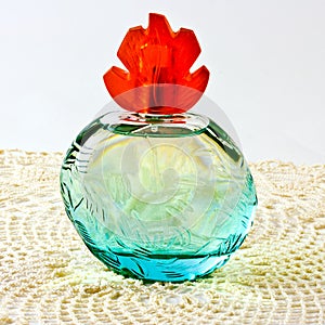 A blue perfume bottle with a red top.