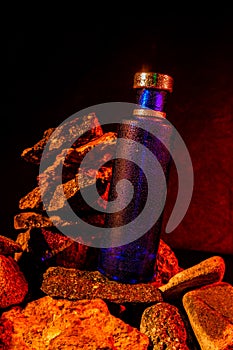 A blue perfume bottle with rocks in the river background