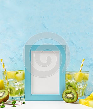 Blue Photo frame mockup: cool and fresh kiwi watermelon lemonade with ingredients on blue background. Vegetarian food, healthy lif