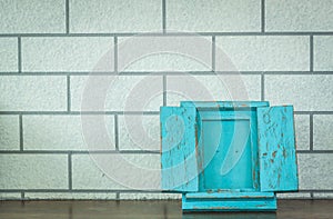 Blue photo frame on wood deck and brick wall background