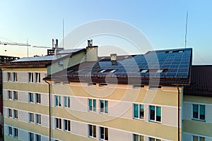 Blue photovoltaic solar panels mounted on industrial building roof for producing clean ecological electricity