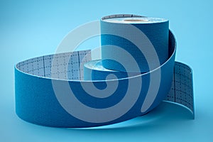 Blue Physio or Kinesiology Tape Rolls on Matching Background Concept for Supportive Athletic Care, Enhancing Physical Flexibility