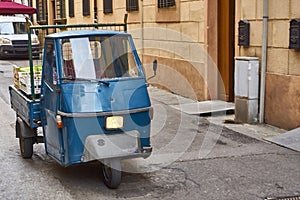 Blue Piaggio Ape Driving Through Old Italian Town