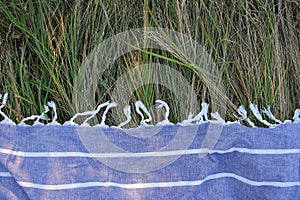 Blue picnic blanket on green grass background. Top view, copy space.