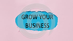 Blue piece of paper in torn pink background with text Grow Your Business.