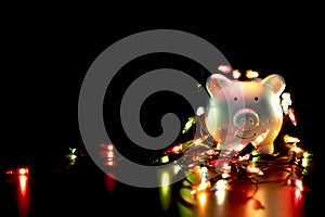 Blue piggy bank with Christmas string lights on happy December festival, Enjoy savings for spending money on the holiday`s concep