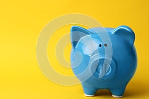 Blue piggy bank on color background.