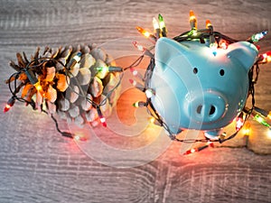 Blue piggy bank and pinecone with Party lights, Enjoy savings for the holidays concept