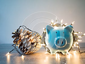 Blue piggy bank and pinecone with Party lights, Enjoy savings for the holidays concept