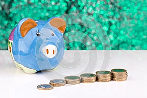 Blue piggy bank with stack of coins: budgetting photo