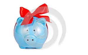 Blue piggy bank on white background. Blue pig with red bow. Toy pig.