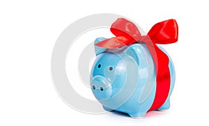 Blue piggy bank on white background. Piggy bank with red bow.