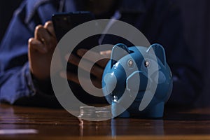 Blue piggy bank on wood table. Saving and investing concepts