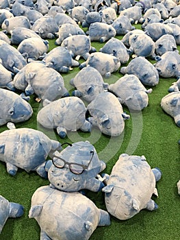 Blue piglet dolls on green field