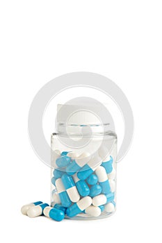 Blue pills in a bottle isolated on white background