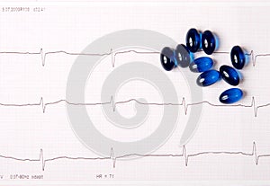 Blue pills on ECG chart (electrocardiogram)