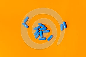 Blue pills on orange abstract background