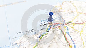 A blue pin stuck in A Coruna on a map of Spain