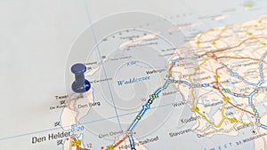 A blue pin stuck in the island of Texel on a map of the Netherlands