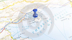 A blue pin stuck in the island of Thasos on a map of Greece photo