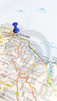 A blue pin stuck in Palermo Sicily on a map of Italy portrait