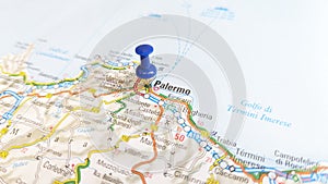 A blue pin stuck in Palermo Sicily on a map of Italy