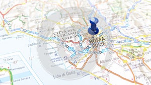 A blue pin stuck in Rome on a map of Italy