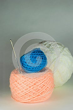 Blue and pink balls of yarn and a crochet hook.