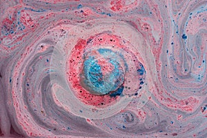 Blue and pink bath bomb swirls in water