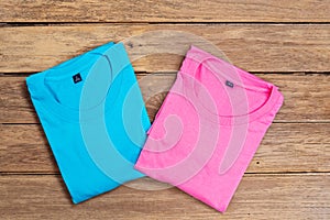 Blue and pink cotton T-shirt put on wooden floor background