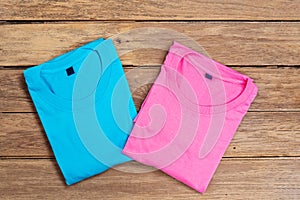 Blue and pink cotton T-shirt put on wooden floor background