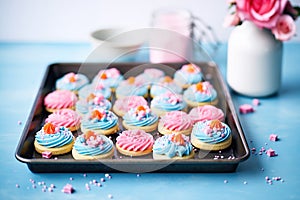 blue and pink frosted cupcakes on a tray