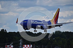 Blue plane with yellow and red empennage landing at T.F. Green Airport