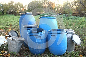 The blue plastic barrels for storage of chemicals . Stockpile of used blue plastic drums for storing water and other liquids