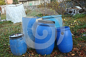 The blue plastic barrels for storage of chemicals . Stockpile of used blue plastic drums for storing water and other liquids