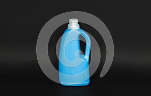 Blue plastic bottle with a grey cap isolated on black background for liquid detergent laundry or cleaning agent