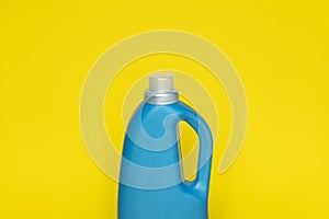 Blue plastic bottle with a grey cap isolated on yellow background for liquid detergent laundry or cleaning agent