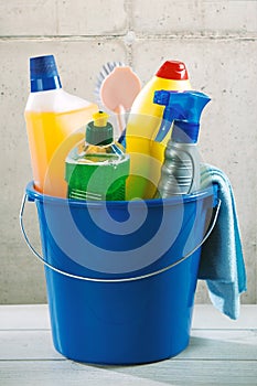 Blue plastic bucket filled with cleaning supplies