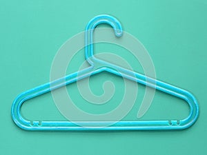 Blue plastic cloth hanger on blue background