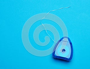 Blue plastic packaging with dental floss on a blue background